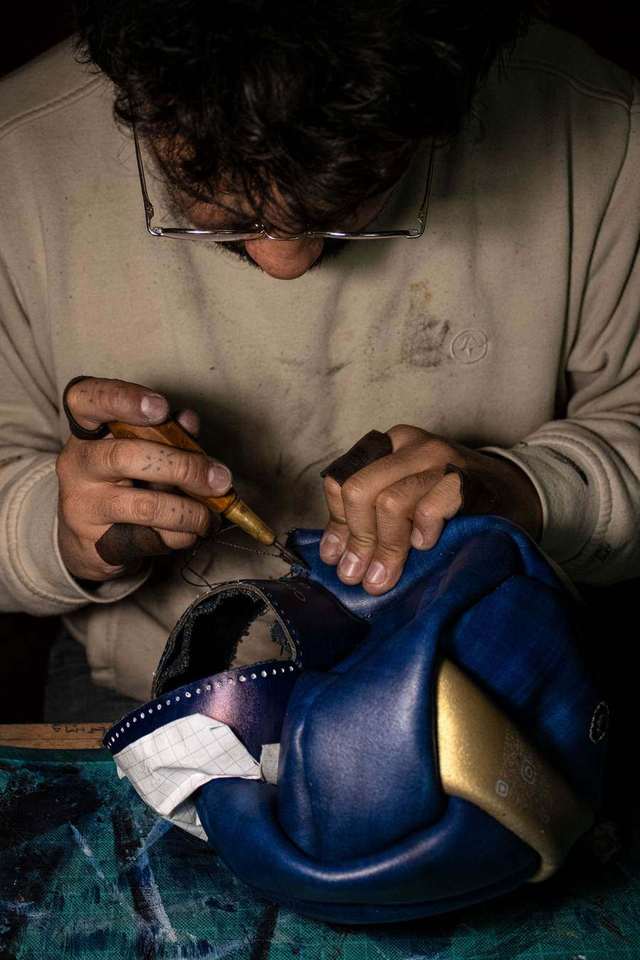 Maestro cosiendo un balón de cuero a mano